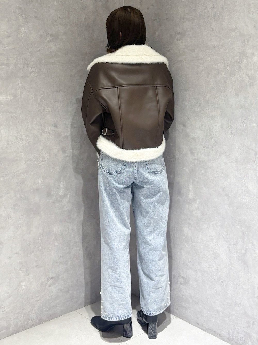 ブルー系のデニムパンツ、ベージュ系のニット/セーター、ブラック系のブーツを着用したレディースの冬コーディネートの4枚目の写真