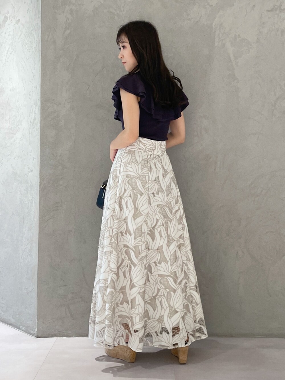 ブラック系のサンダル、ブラック系のボストンバッグ、ホワイト系のスカートを着用したレディースの春コーディネートの4枚目の写真