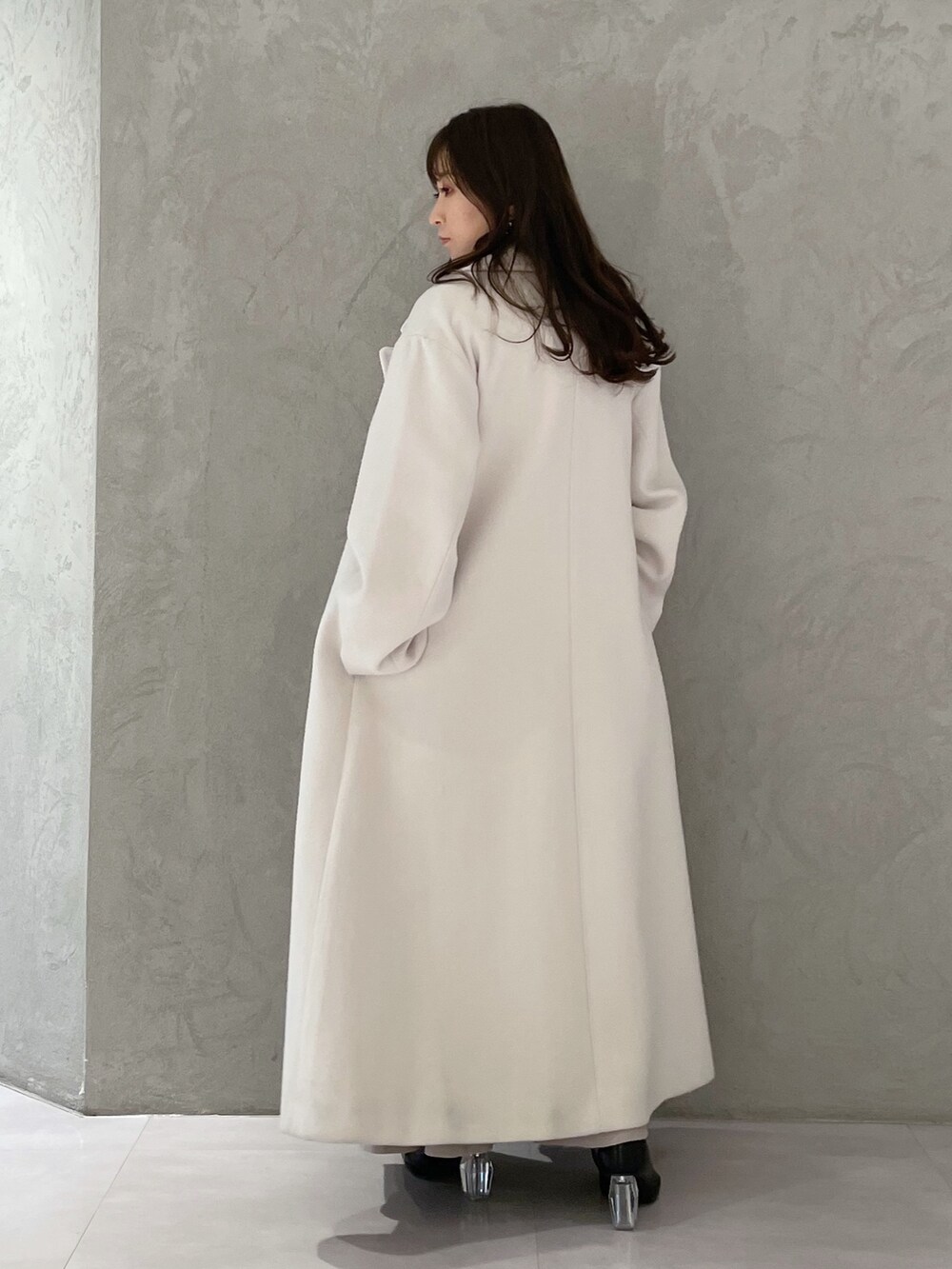 ベージュ系のワンピース、ホワイト系のチェスターコート、ブラック系のブーツを着用したレディースの冬コーディネートの6枚目の写真