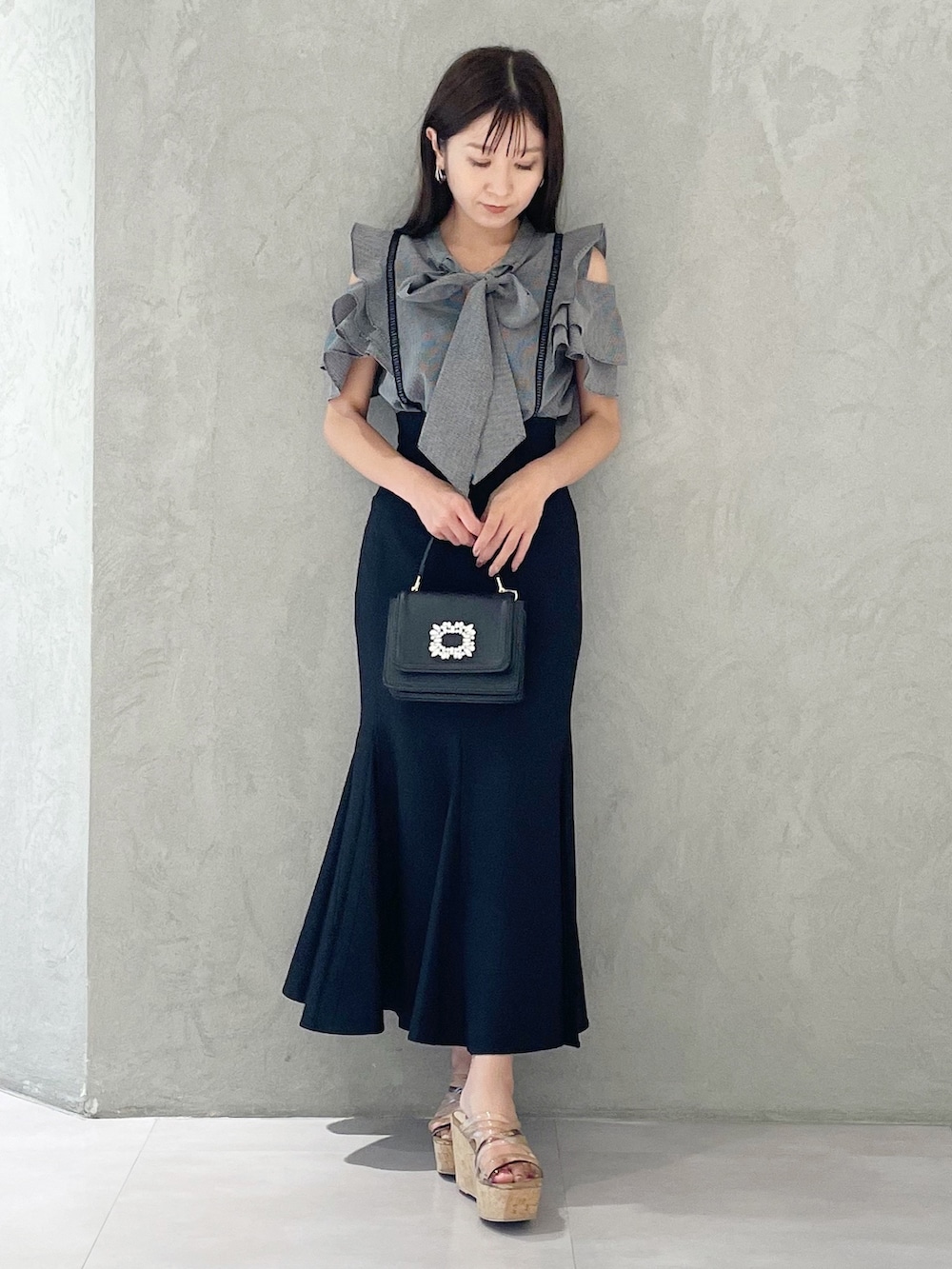 ブラック系のスカート、ブラウン系のサンダル、ブラック系のショルダーバッグを着用したレディースの夏コーディネートの5枚目の写真