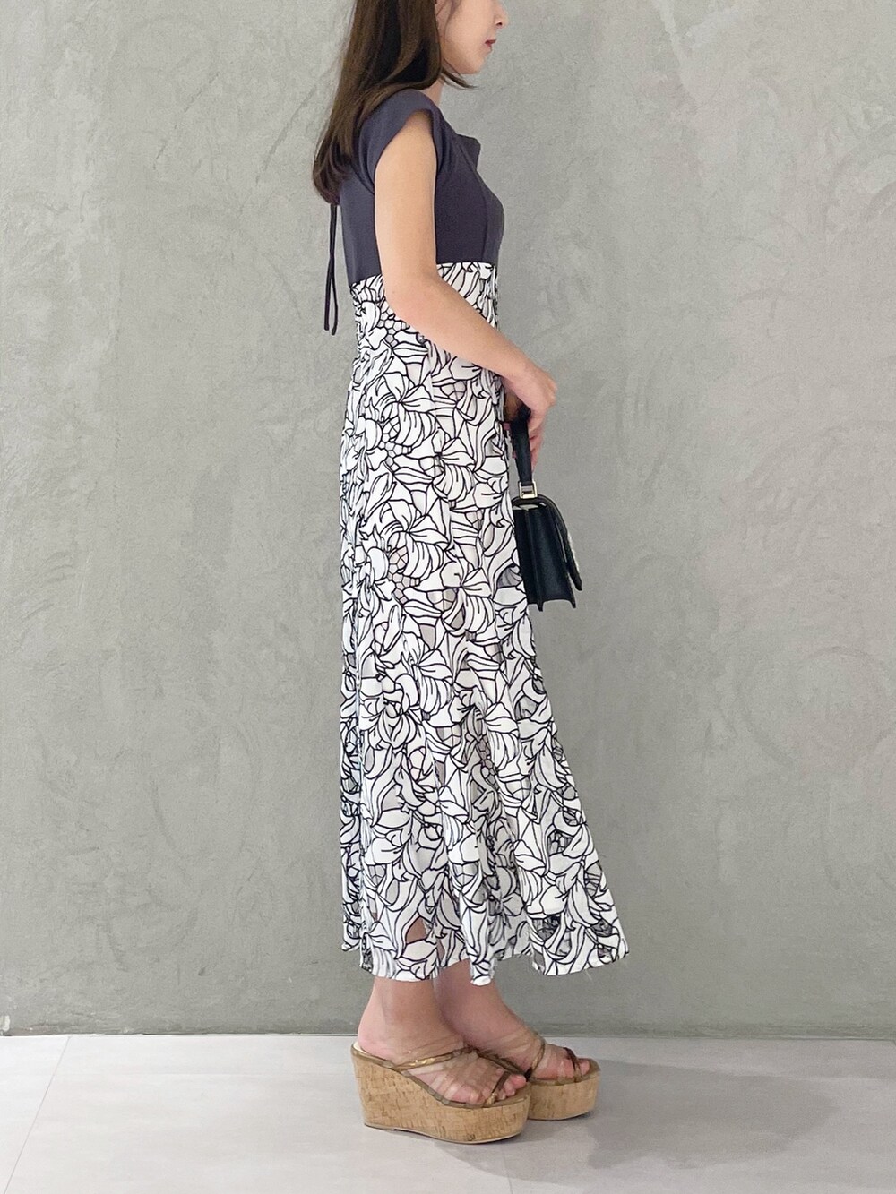 ブラック系のショルダーバッグ、ブラウン系のサンダル、ホワイト系のワンピースを着用したレディースの夏コーディネートの2枚目の写真