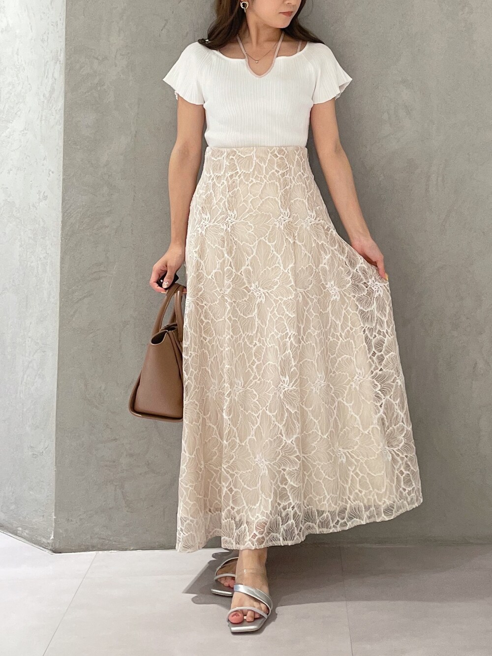 ブラウン系のトートバッグ、ホワイト系のニット/セーター、ベージュ系のスカートを着用したレディースの夏コーディネートの5枚目の写真