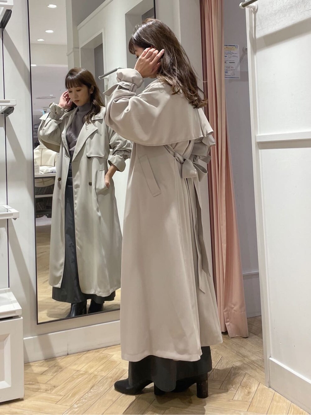 ベージュ系のトレンチコート、グレー系のスカート、グレー系のスカートを着用したレディースの秋コーディネートの2枚目の写真