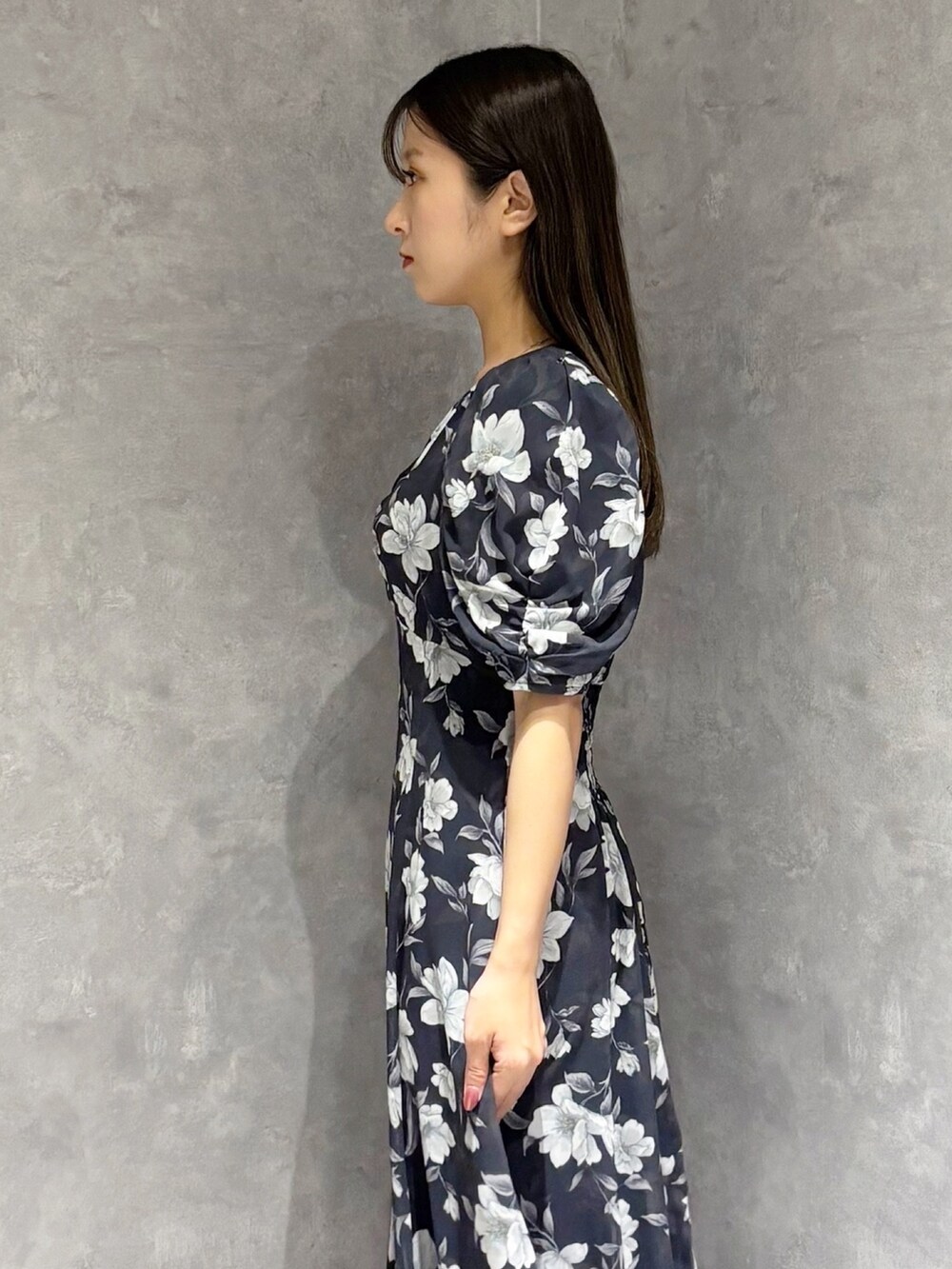 ブルー系のワンピース、ブルー系のパンプス、ホワイト系のハンドバッグを着用したレディースの春コーディネートの6枚目の写真