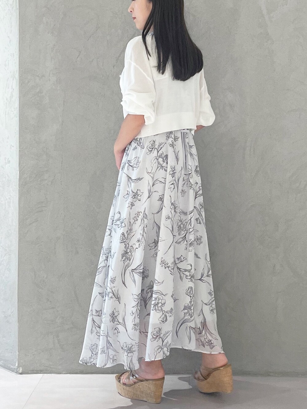 グレー系のワンピース、ブラウン系のサンダル、ホワイト系のショルダーバッグを着用したレディースの夏コーディネートの3枚目の写真