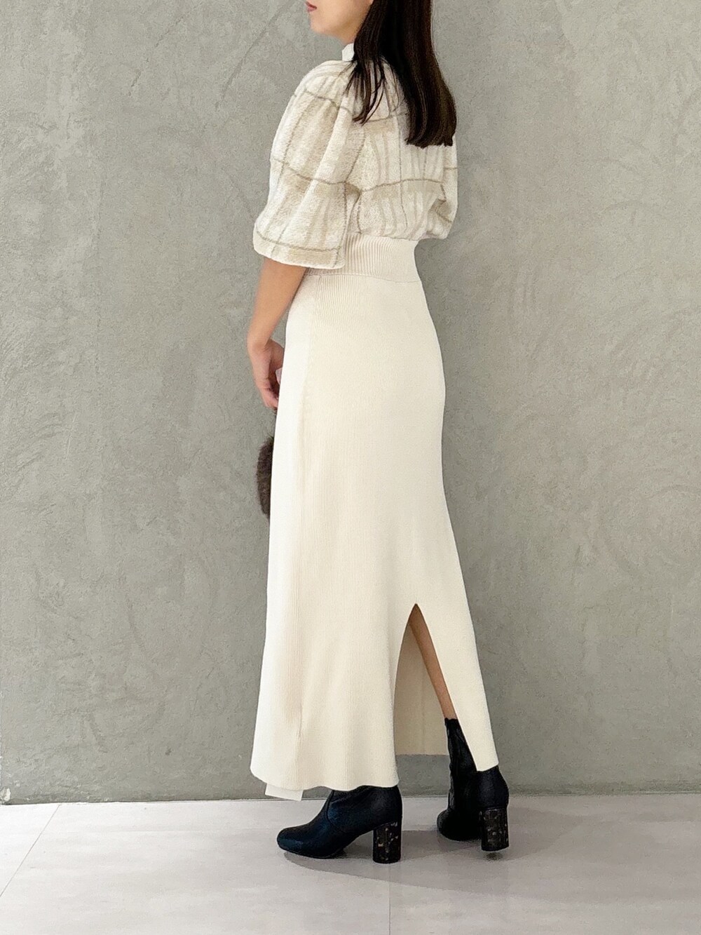 ホワイト系のワンピース、ブラック系のブーツ、ブラウン系のハンドバッグを着用したレディースの秋コーディネートの5枚目の写真