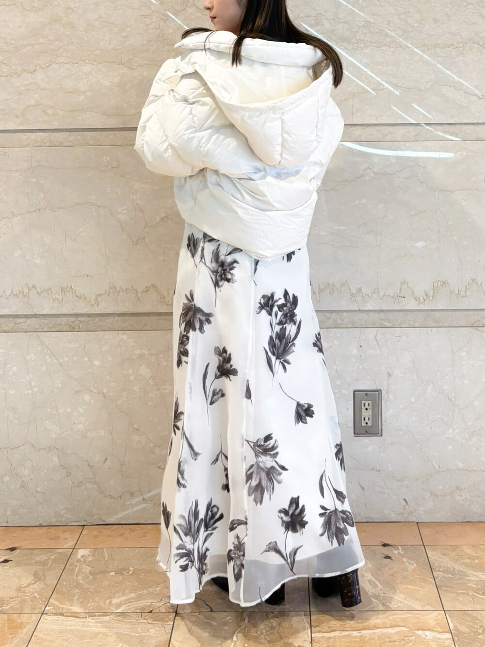 ホワイト系のスカート、ブラック系のブーツ、レッド系のカーディガン/ボレロを着用したレディースの冬コーディネートの5枚目の写真