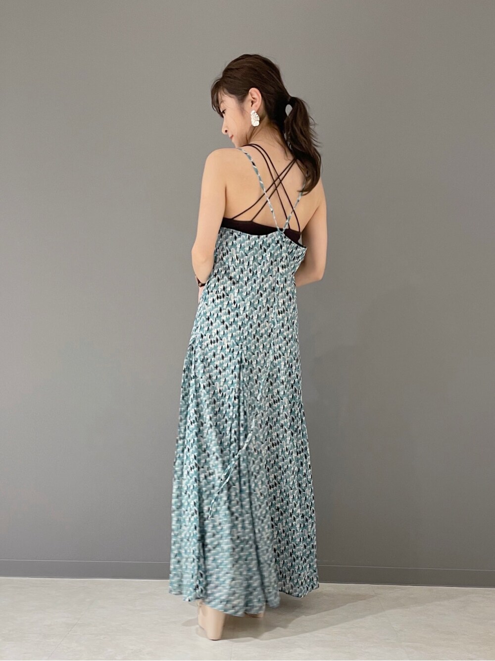 グリーン系のワンピース、ホワイト系のハンドバッグ、ホワイト系のサンダルを着用したレディースの春コーディネートの6枚目の写真