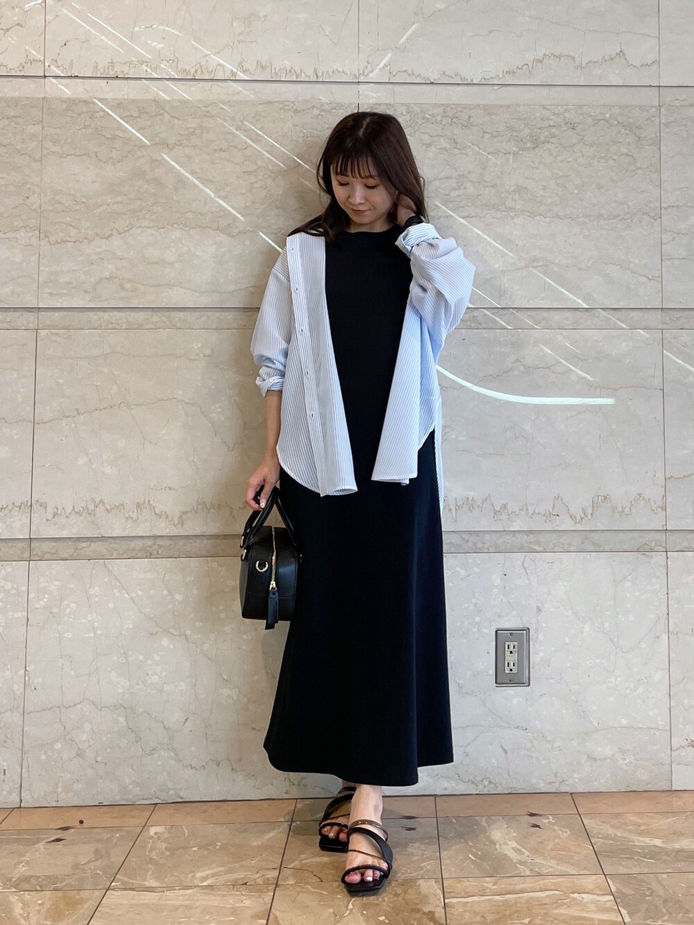 ホワイト系のボストンバッグ、ブラック系のサンダル、ブルー系のシャツ/ブラウスを着用したレディースの春コーディネートの6枚目の写真