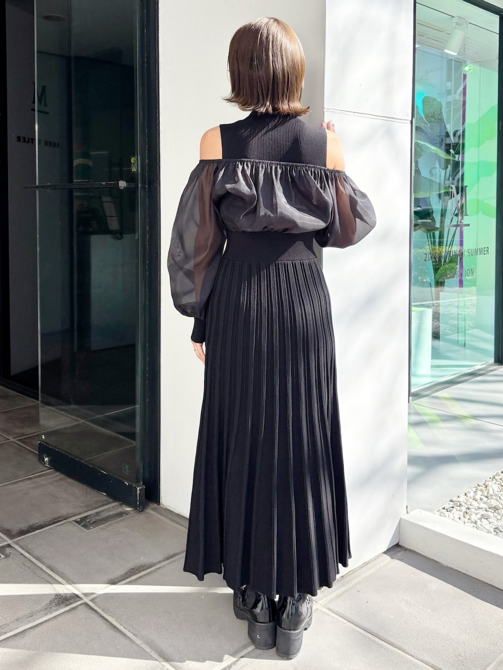 ブラック系のワンピース、ブラック系のブーツを着用したレディースの冬コーディネートの2枚目の写真