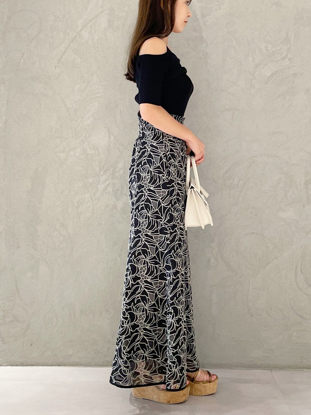 ブラック系のスカート、ブラウン系のサンダル、ベージュ系のショルダーバッグを着用したレディースの夏コーディネートの4枚目の写真