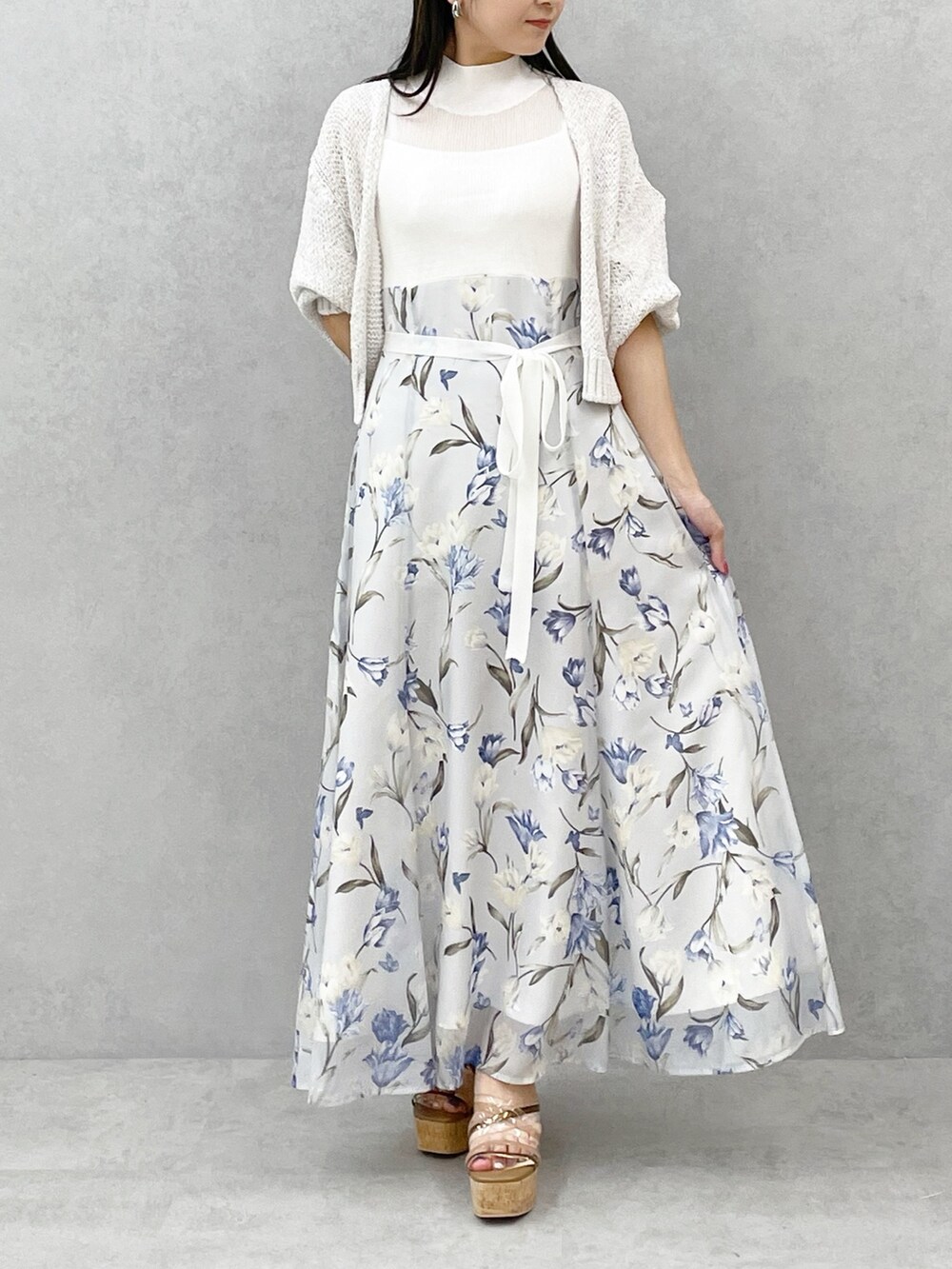 ブラウン系のサンダル、ブルー系のワンピース、ホワイト系のカーディガン/ボレロを着用したレディースの春コーディネートの4枚目の写真