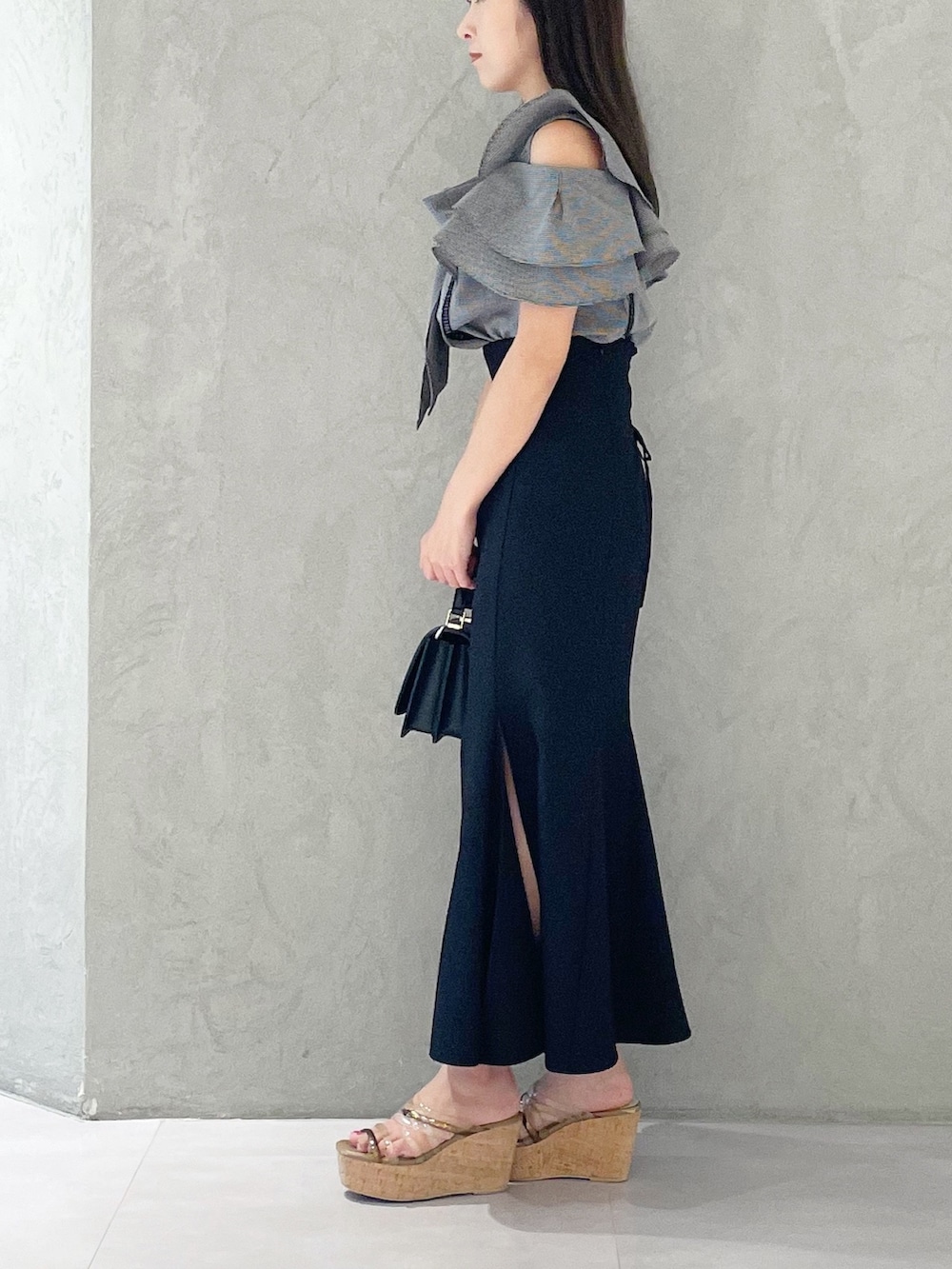 ブラック系のスカート、ブラウン系のサンダル、ブラック系のショルダーバッグを着用したレディースの夏コーディネートの3枚目の写真