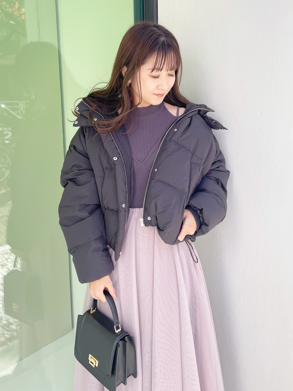 グレー系のワンピース、ブラック系のダウンジャケット/コート、ブラック系のハンドバッグを着用したレディースの冬コーディネートの6枚目の写真