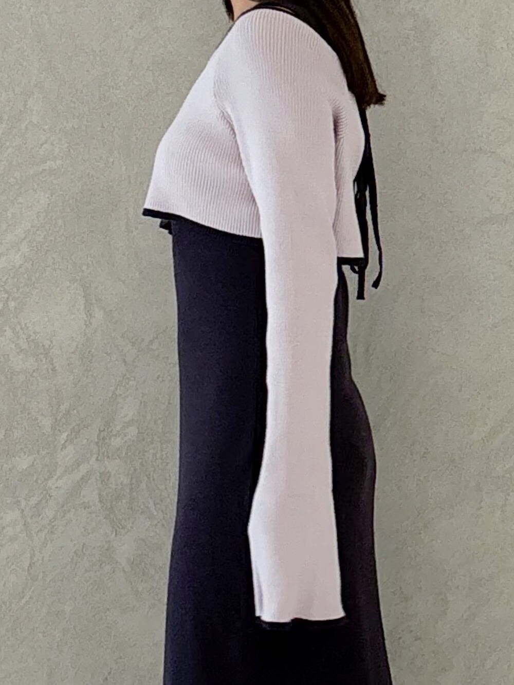 グレー系のワンピース、ブラック系のブーツ、ホワイト系のハンドバッグを着用したレディースの秋コーディネートの4枚目の写真