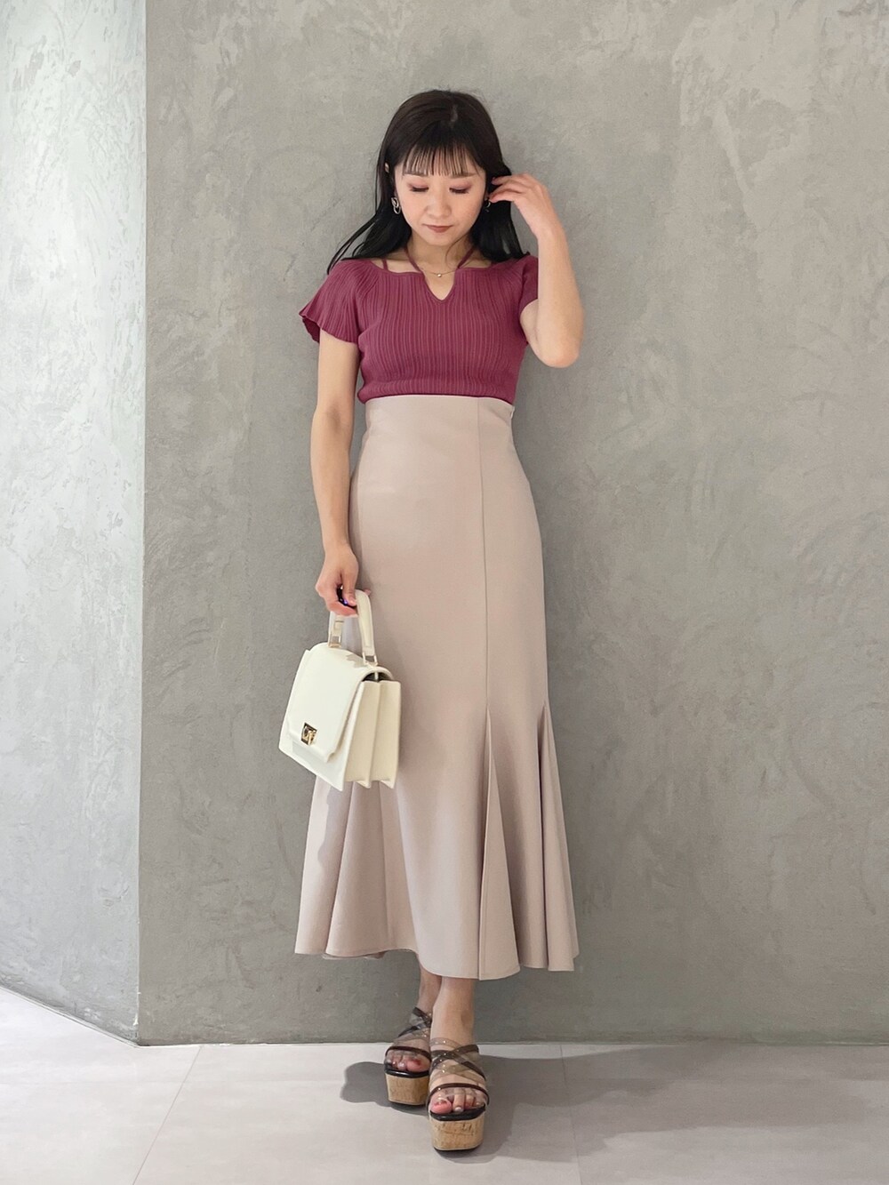 ブラック系のサンダル、ホワイト系のハンドバッグ、ピンク系のスカートを着用したレディースの春コーディネートの5枚目の写真