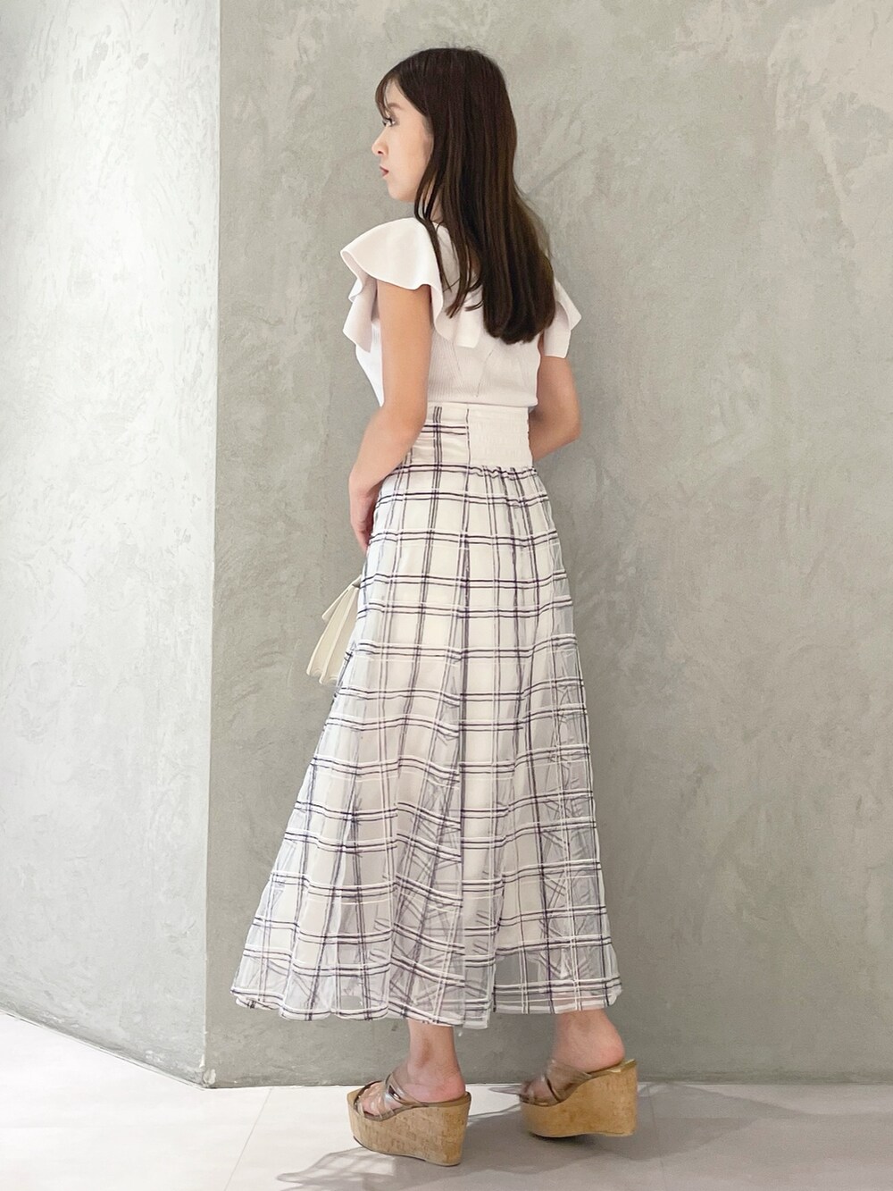 ホワイト系のスカート、ブラウン系のサンダル、ベージュ系のショルダーバッグを着用したレディースの夏コーディネートの5枚目の写真