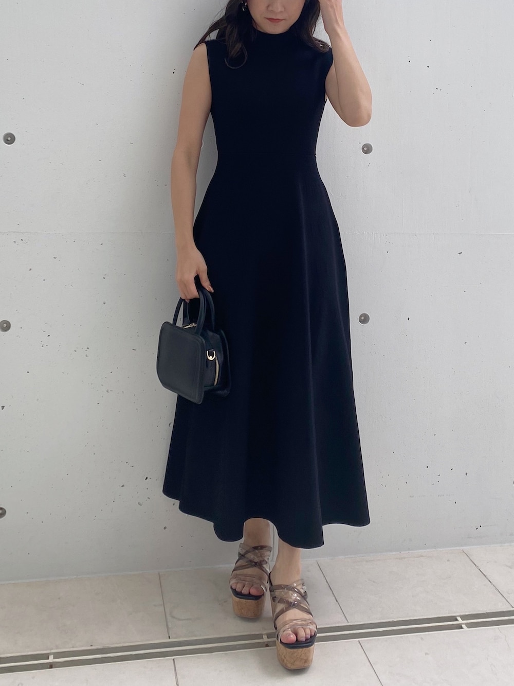 ブラック系のワンピース、ブラック系のサンダル、ブラック系のハンドバッグを着用したレディースの春コーディネートの4枚目の写真