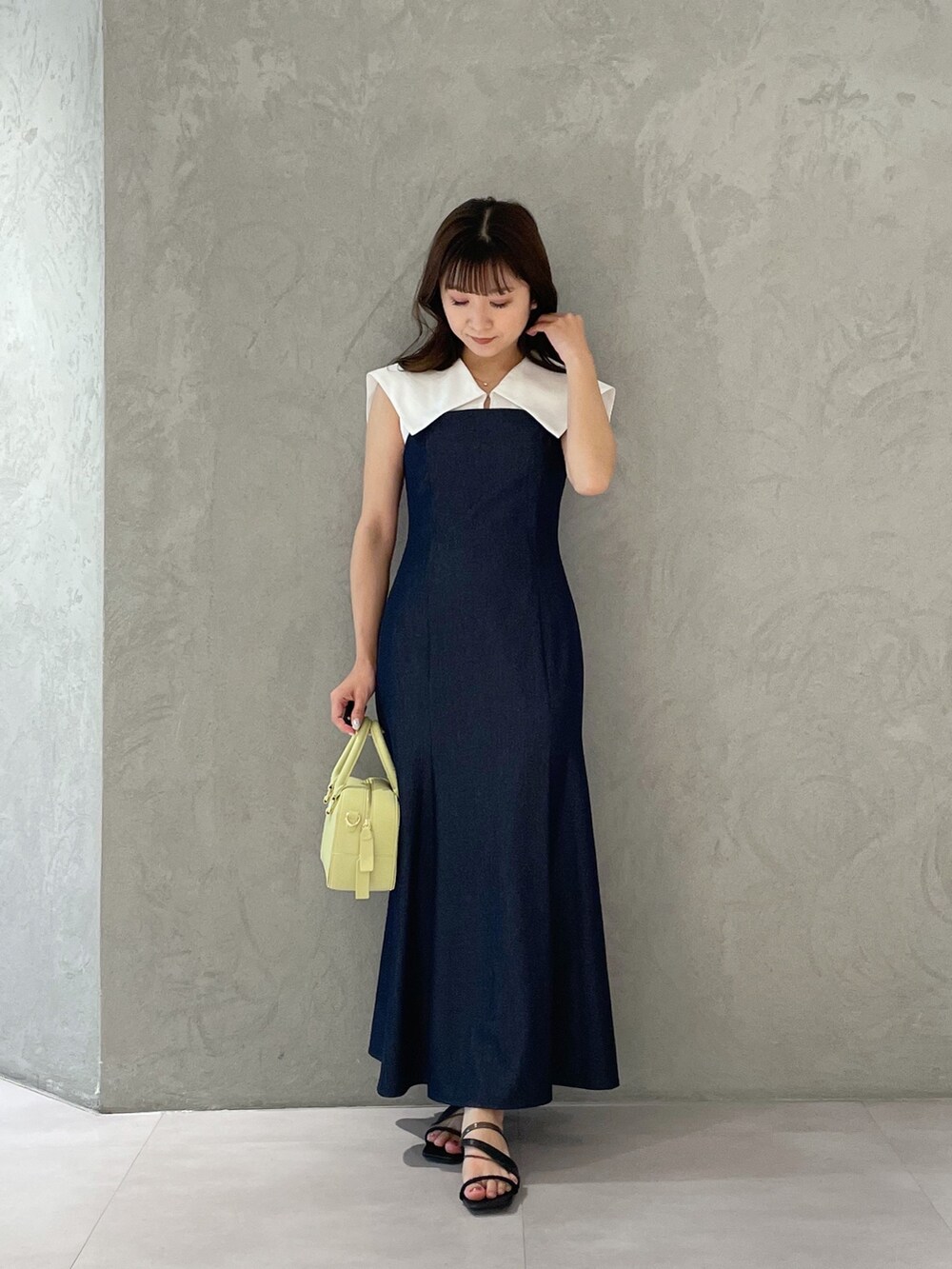 ブルー系のワンピース、イエロー系のボストンバッグ、ブラック系のサンダルを着用したレディースの春コーディネートの8枚目の写真