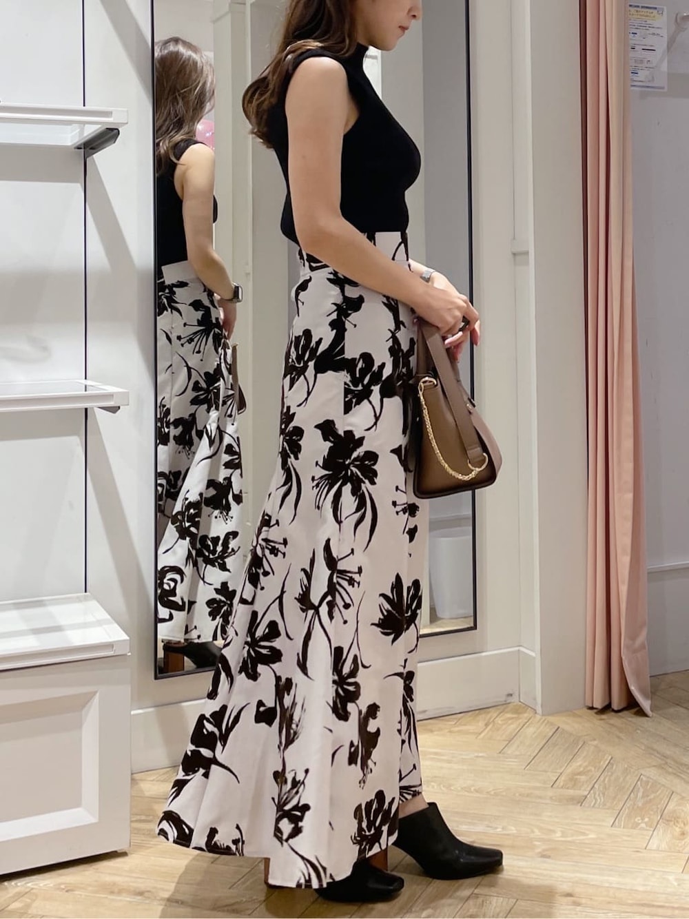 ホワイト系のスカート、ブラック系のサンダル、ブラック系のニット/セーターを着用したレディースの夏コーディネートの2枚目の写真