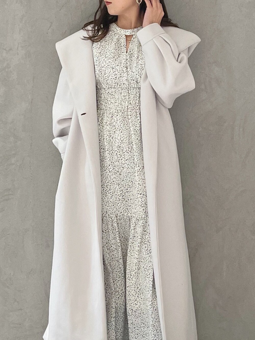 ホワイト系のワンピース、ホワイト系のチェスターコート、ブラック系のブーツを着用したレディースの冬コーディネートの4枚目の写真