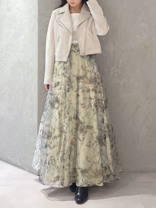 グレー系のライダースジャケット、イエロー系のスカート、ホワイト系のニット/セーターを着用したレディースの秋コーディネートの2枚目の写真