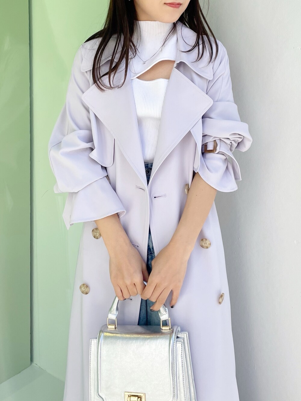 シルバー系のハンドバッグ、ブラック系のサンダル、ブルー系のデニムパンツを着用したレディースの春コーディネートの4枚目の写真