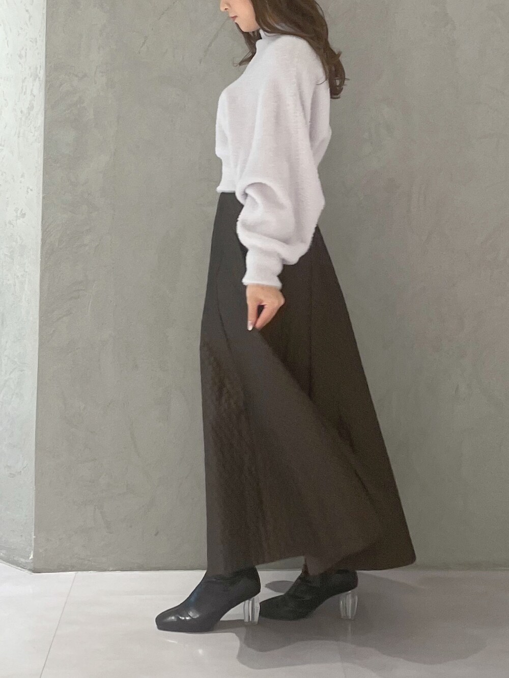 ブラウン系のスカート、パープル系のニット/セーターを着用したレディースの冬コーディネートの3枚目の写真