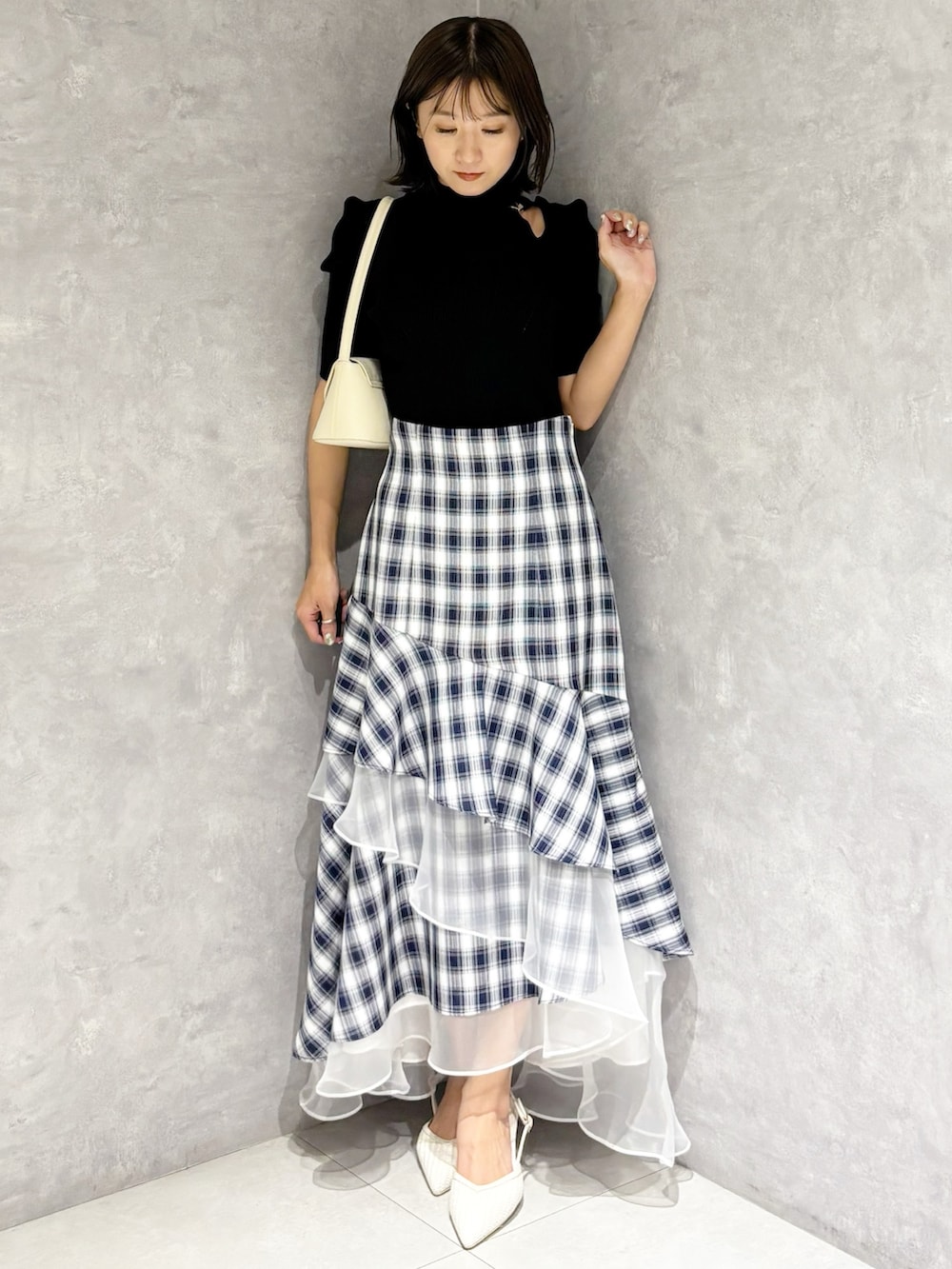 その他のスカート、ホワイト系のパンプス、ブラック系のニット/セーターを着用したレディースの春コーディネートの5枚目の写真