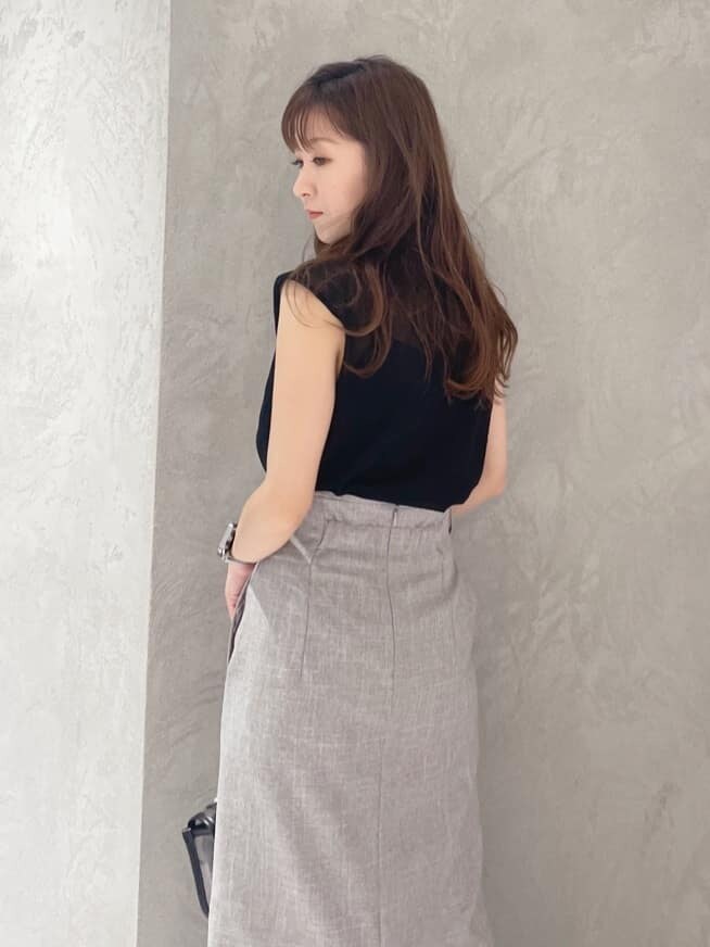 ブラック系のショルダーバッグ、ブラック系のニット/セーター、ブラウン系のサンダルを着用したレディースの夏コーディネートの6枚目の写真