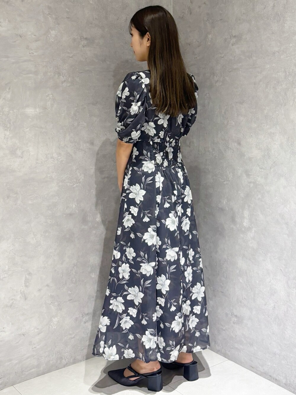 ブルー系のワンピース、ブルー系のパンプス、ホワイト系のハンドバッグを着用したレディースの春コーディネートの4枚目の写真