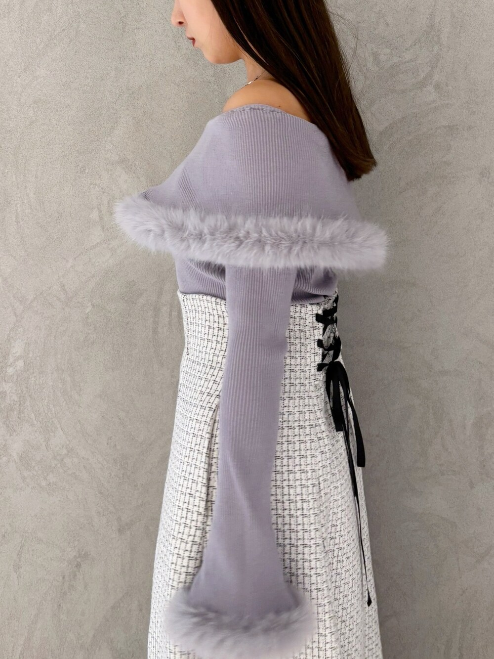 ホワイト系のスカート、ブラック系のブーツ、ホワイト系のショルダーバッグを着用したレディースの冬コーディネートの5枚目の写真