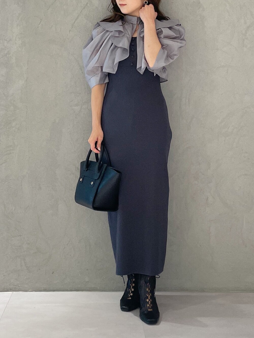 ブラック系のトートバッグ、グレー系のワンピース、ブラック系のブーツを着用したレディースの夏コーディネートの5枚目の写真