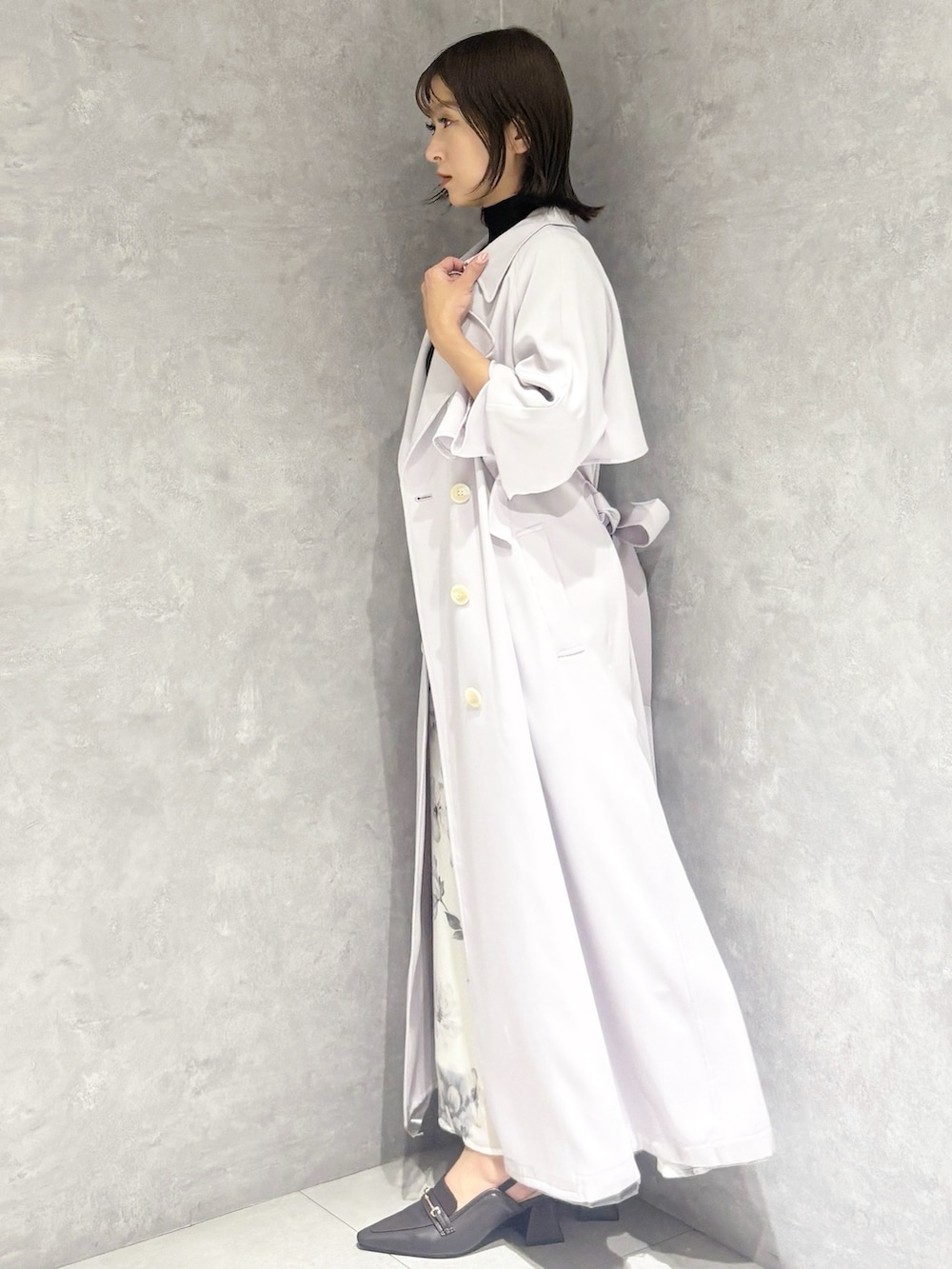 ブラック系のワンピース、ブラウン系のパンプス、パープル系のトレンチコートを着用したレディースの春コーディネートの3枚目の写真