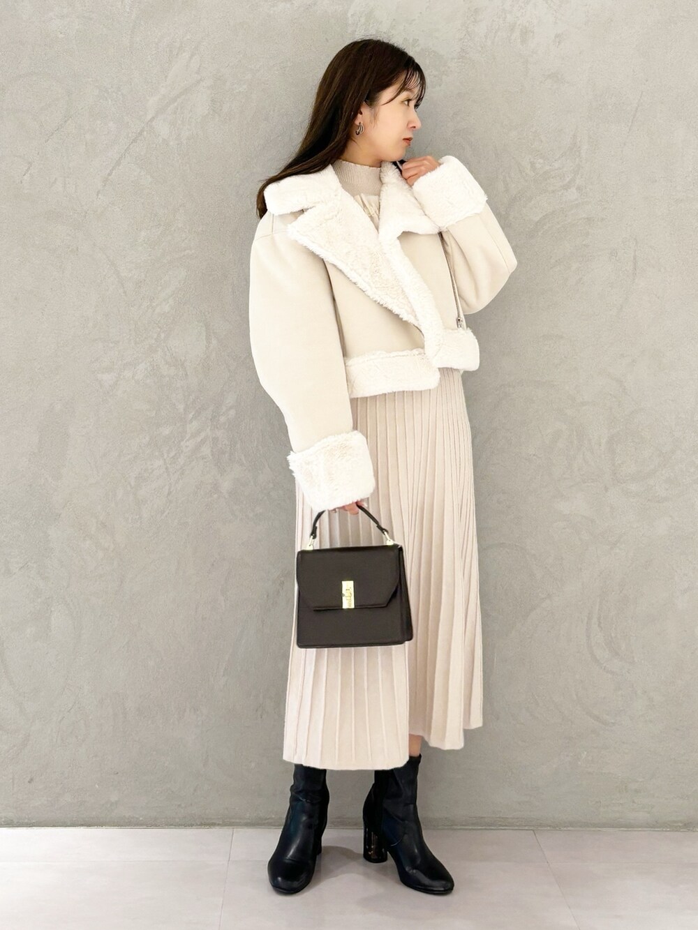 ホワイト系のワンピース、ブラック系のブーツ、ホワイト系のムートンコートを着用したレディースの秋コーディネートの6枚目の写真