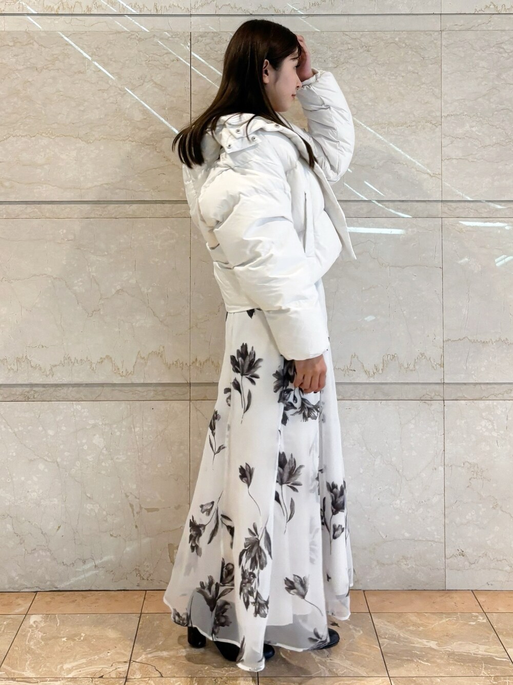 ホワイト系のスカート、ブラック系のブーツ、レッド系のカーディガン/ボレロを着用したレディースの冬コーディネートの7枚目の写真