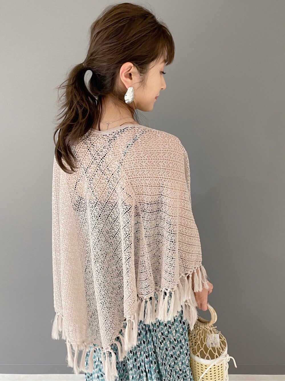 グリーン系のワンピース、ホワイト系のハンドバッグ、ホワイト系のサンダルを着用したレディースの春コーディネートの4枚目の写真