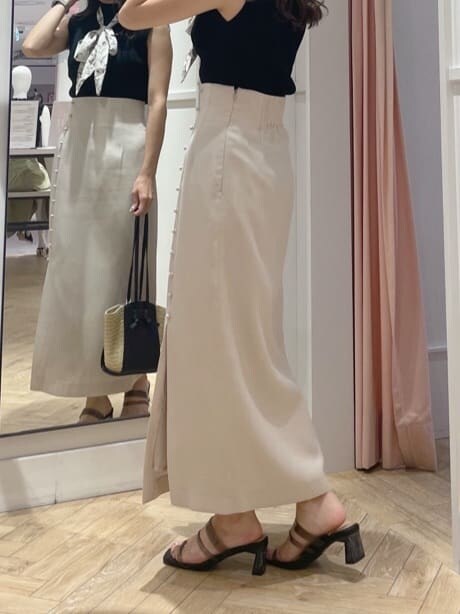 ブラック系のサンダル、ベージュ系のスカート、ブラック系のニット/セーターを着用したレディースの夏コーディネートの3枚目の写真