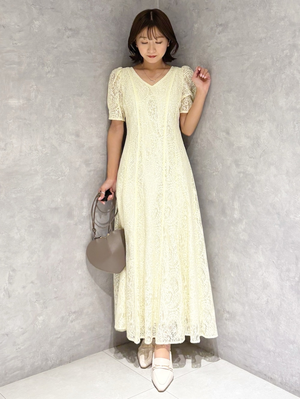 イエロー系のワンピース、ホワイト系のパンプスを着用したレディースの春コーディネートの4枚目の写真