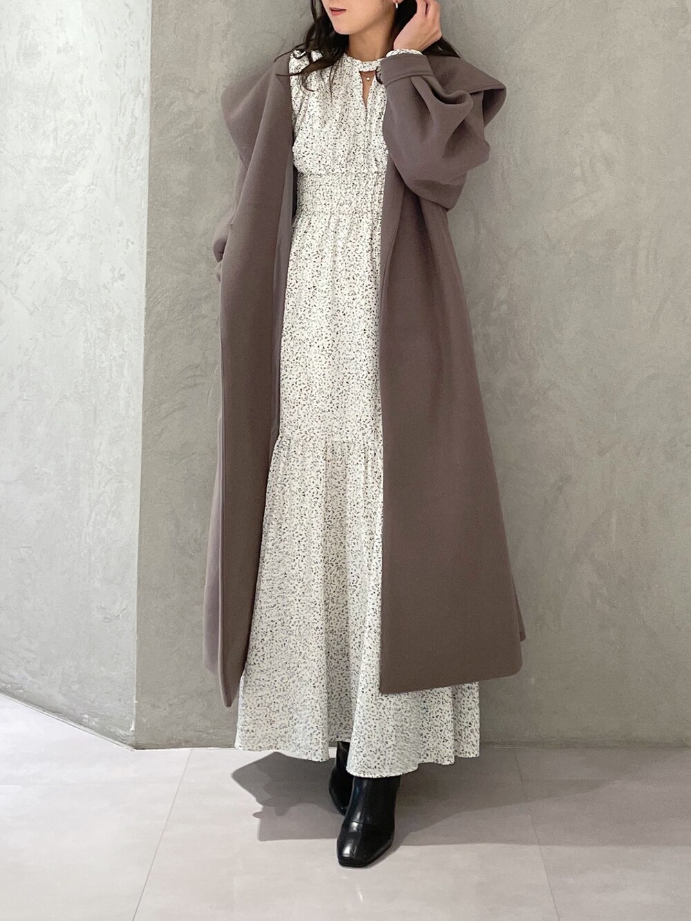 ホワイト系のワンピース、ブラウン系のチェスターコート、ブラック系のブーツを着用したレディースの秋コーディネートの7枚目の写真