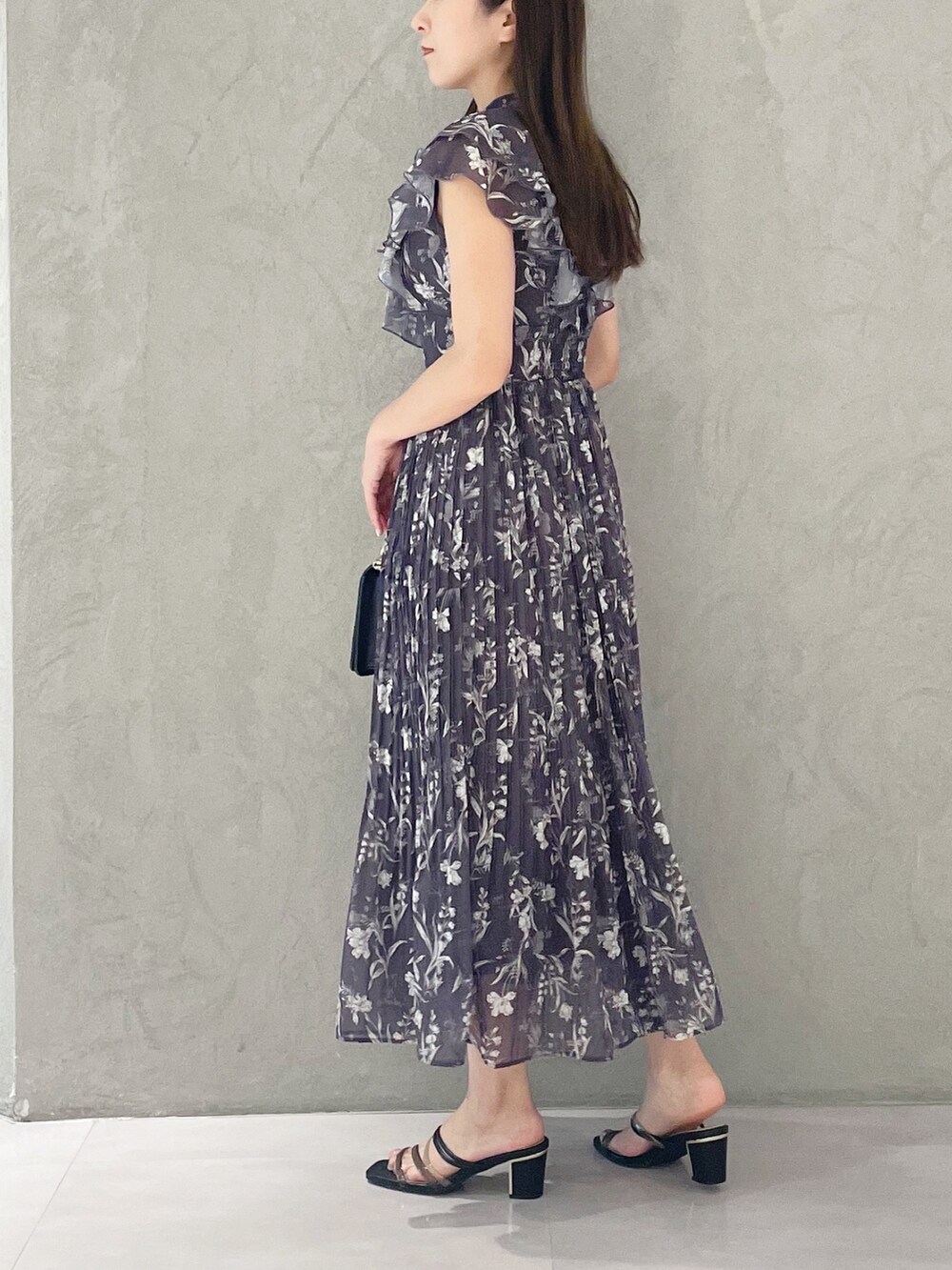 ブラック系のハンドバッグ、ブラック系のサンダル、グレー系のワンピースを着用したレディースの春コーディネートの5枚目の写真