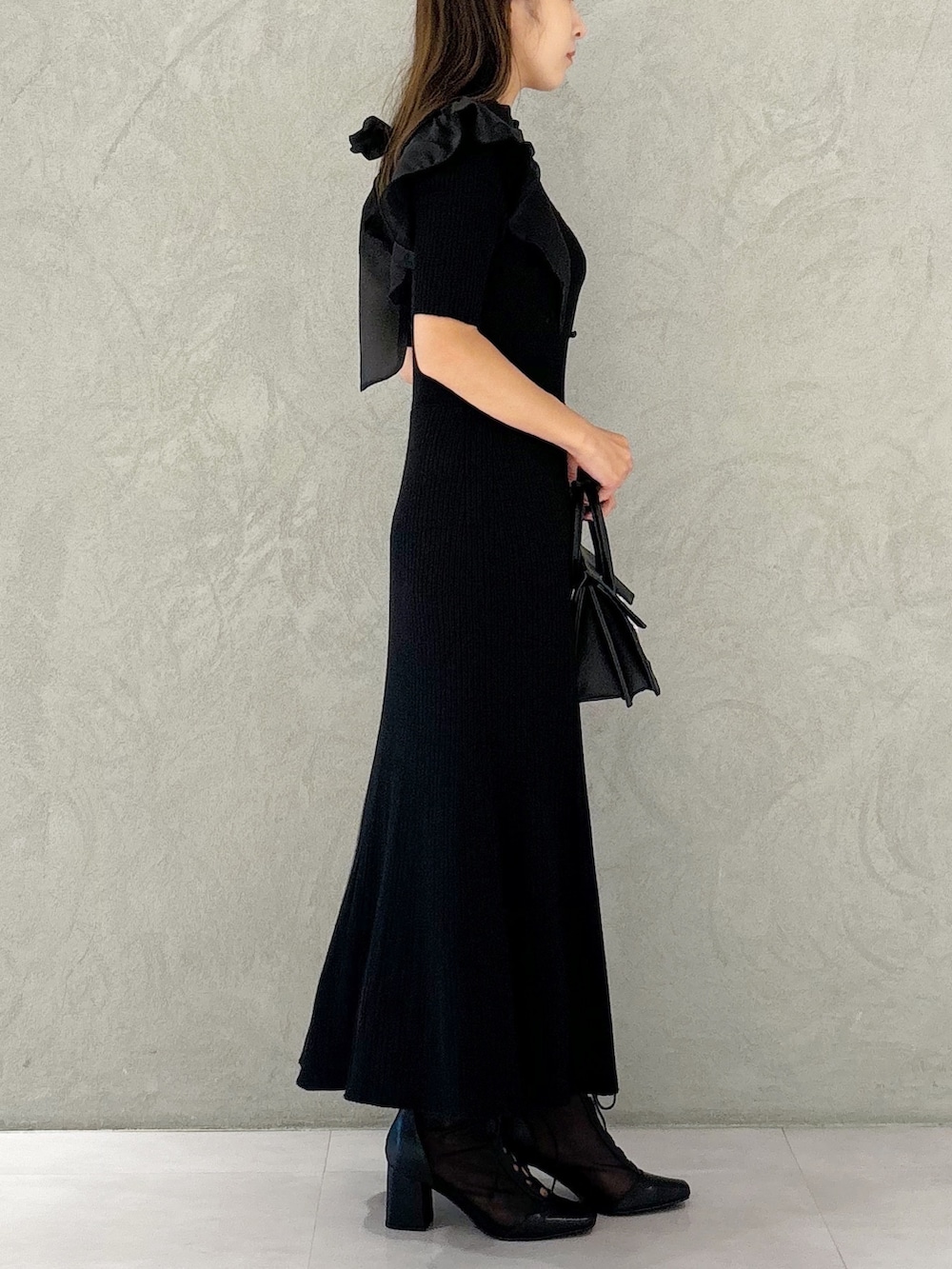 ブラック系のワンピース、ブラック系のショルダーバッグ、ブラック系のブーツを着用したレディースの夏コーディネートの4枚目の写真