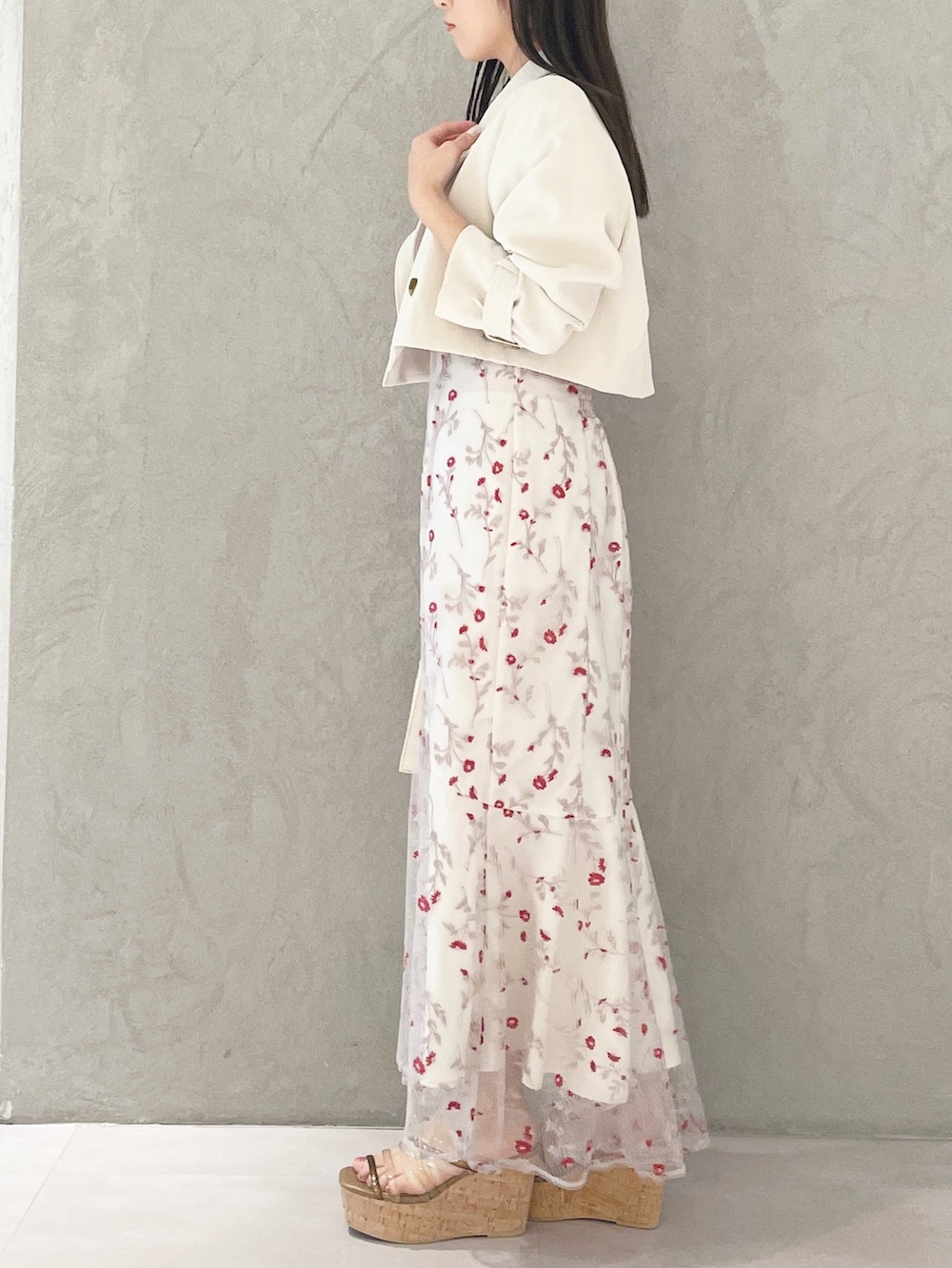 レッド系のワンピース、ブラウン系のサンダル、ホワイト系のショルダーバッグを着用したレディースの春コーディネートの2枚目の写真