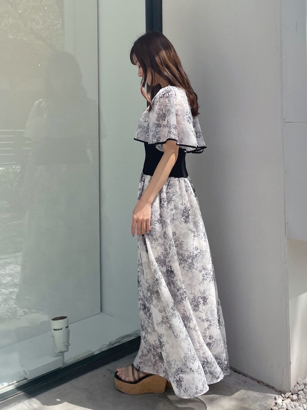 ブラック系のサンダル、ホワイト系のハンドバッグ、ホワイト系のワンピースを着用したレディースの春コーディネートの3枚目の写真