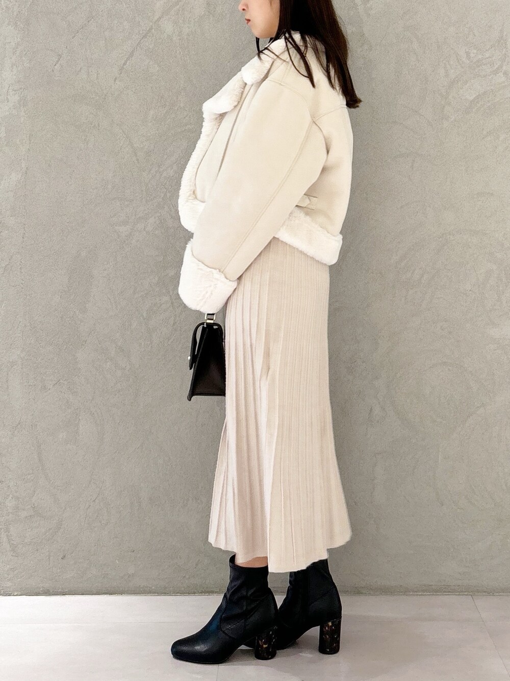 ホワイト系のワンピース、ブラック系のブーツ、ホワイト系のムートンコートを着用したレディースの秋コーディネートの5枚目の写真