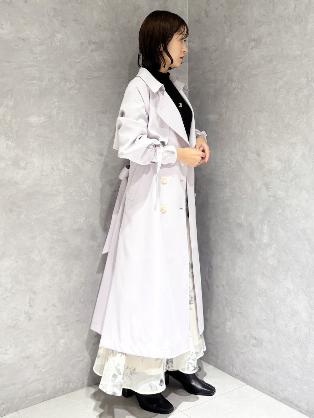 ホワイト系のスカート、ブラック系のニット/セーター、ブラック系のブーツを着用したレディースの冬コーディネートの3枚目の写真