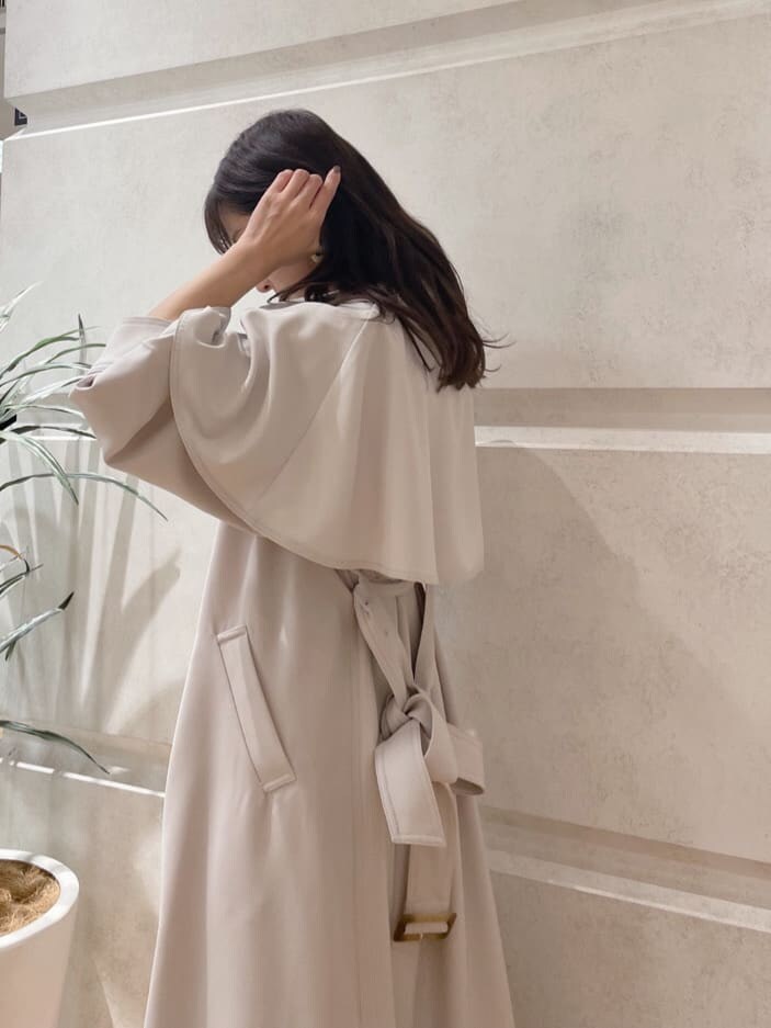 グレー系のトレンチコート、ブラック系のその他シューズ、ホワイト系のハンドバッグを着用したレディースの春コーディネートの6枚目の写真