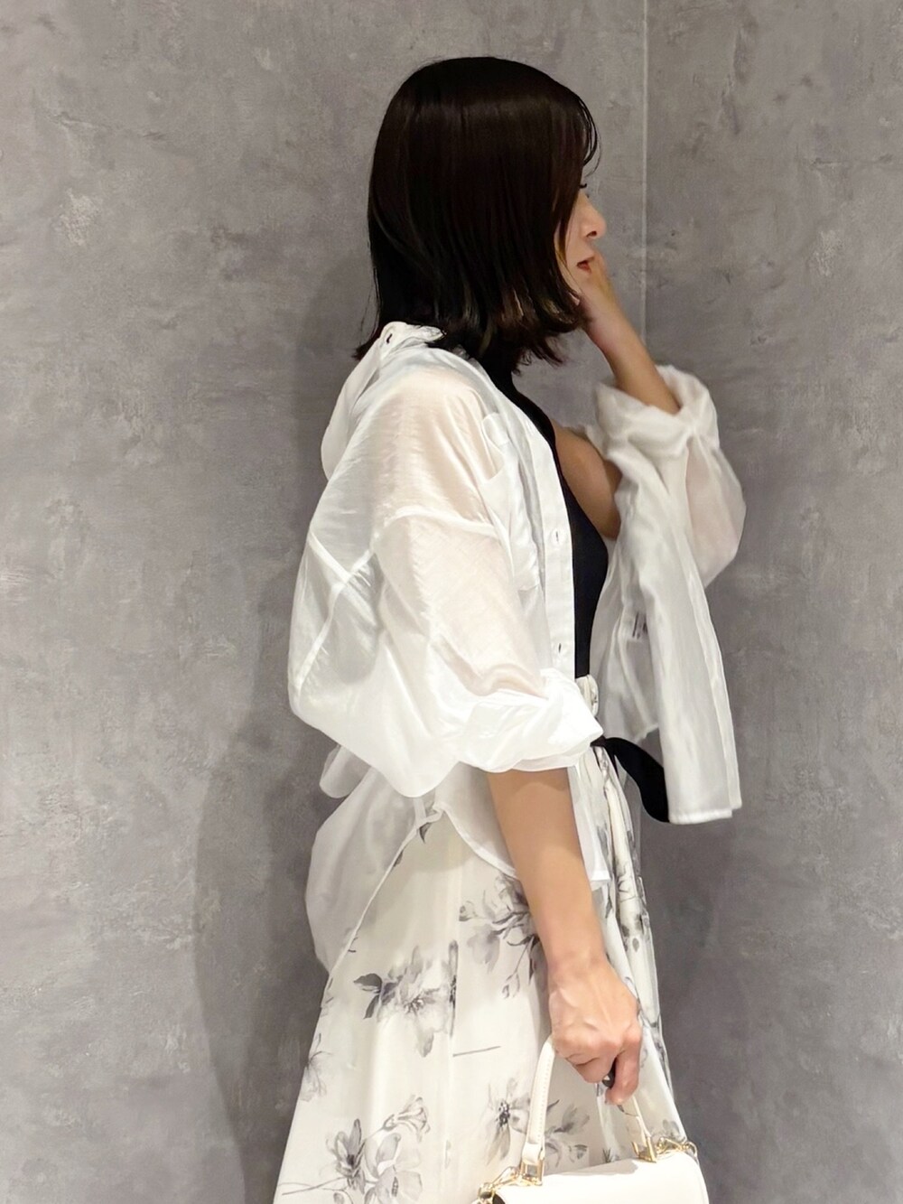 ホワイト系のワンピース、ブラウン系のサンダル、ホワイト系のハンドバッグを着用したレディースの夏コーディネートの5枚目の写真