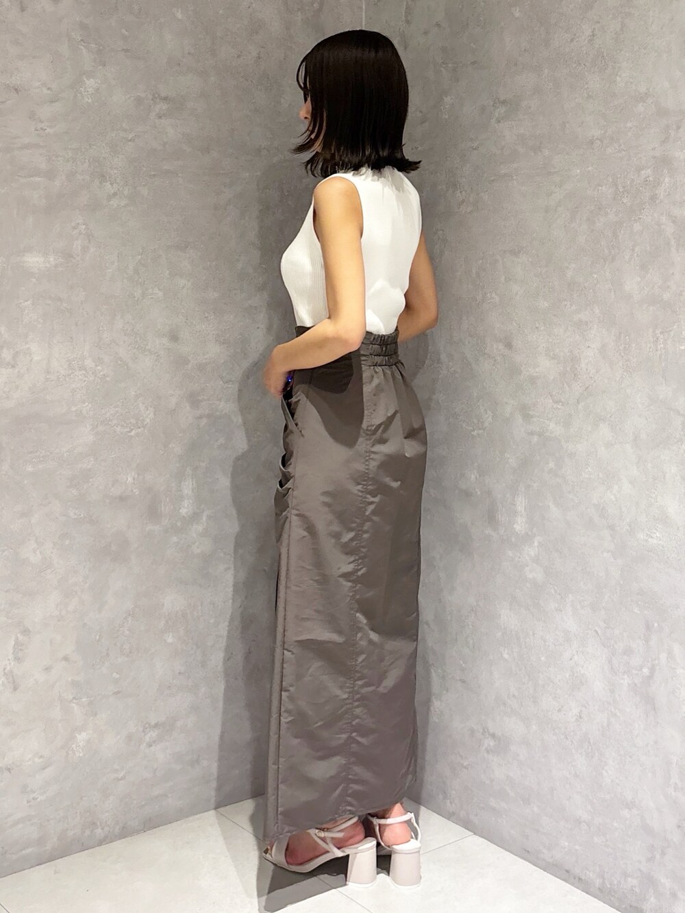 ブラウン系のスカート、ホワイト系のサンダル、ホワイト系のニット/セーターを着用したレディースの夏コーディネートの2枚目の写真