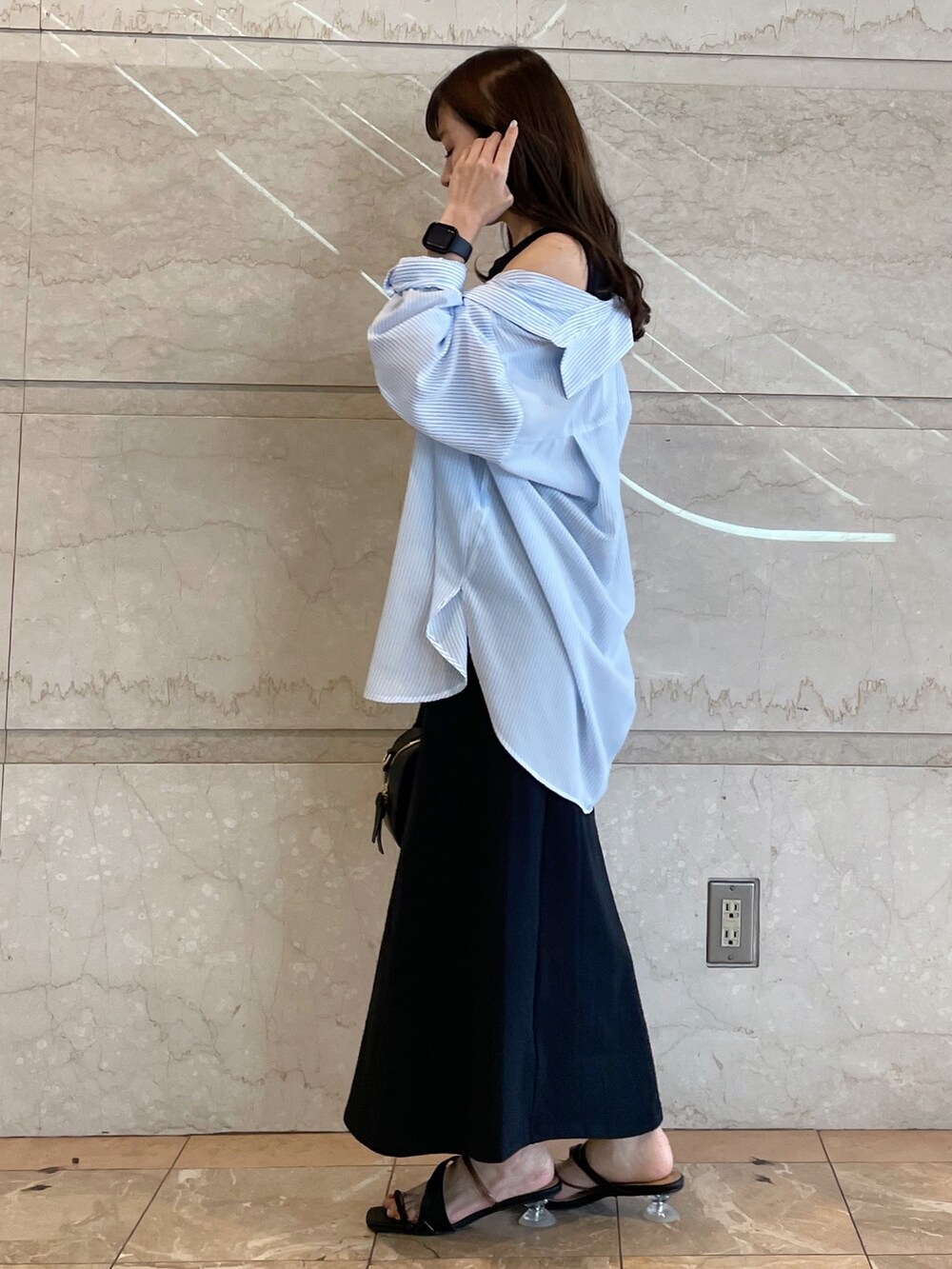 ホワイト系のボストンバッグ、ブラック系のサンダル、ブルー系のシャツ/ブラウスを着用したレディースの春コーディネートの2枚目の写真